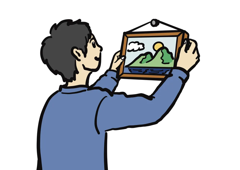 壁にフォトフレームを掛ける様子