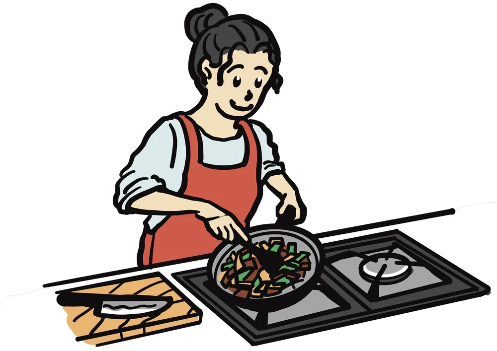 キッチンでエプロンをした女性がフライパンを持って、野菜を炒めている様子