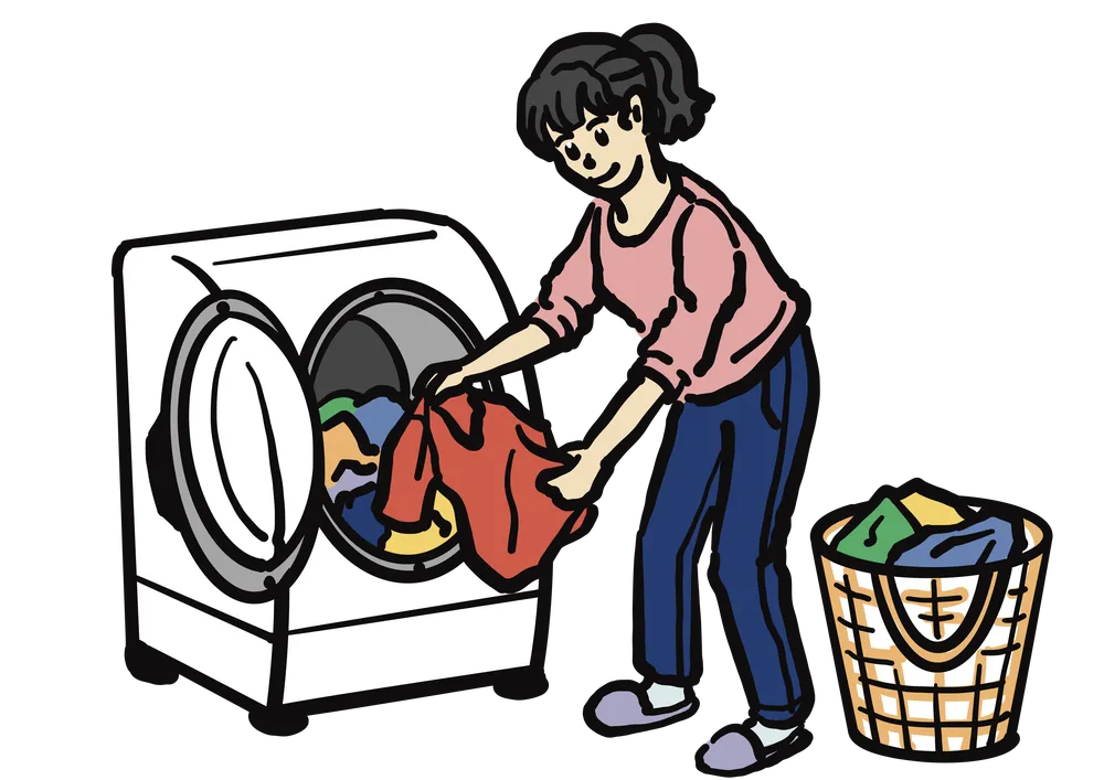ドラム式洗濯機に洋服を入れようとする女性
