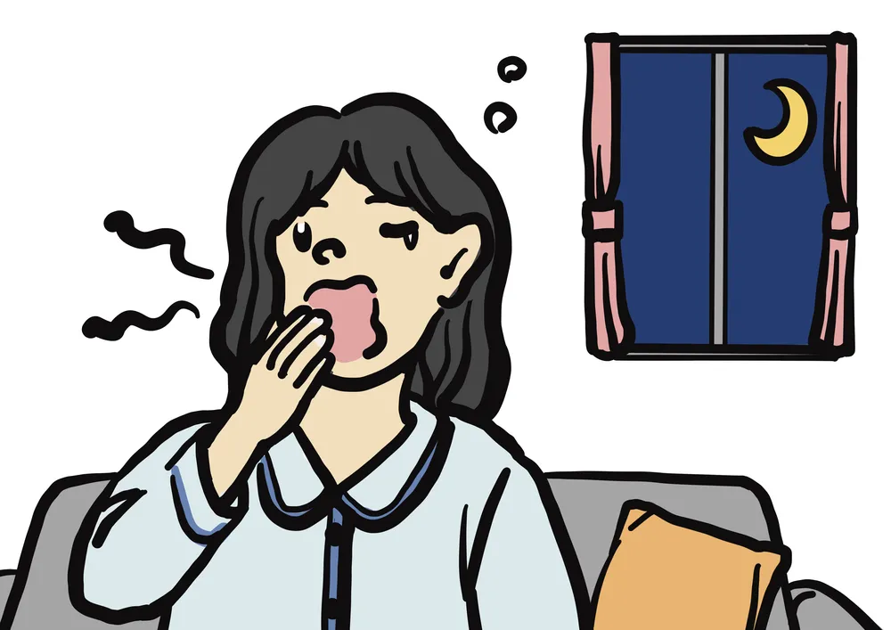 ソファの上でパジャマ姿であくびをする女性。背景の窓から月が見えている。